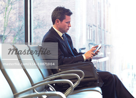 Businessman using cell phone in airport