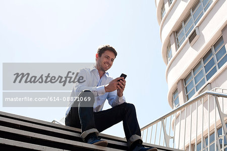 Businessman on cell phone on city street