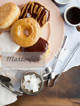 Plate of donuts with coffee and sugar Plate of donuts with coffee and sugar