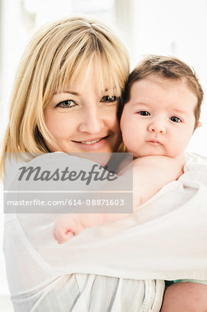 Portrait of mid adult mother embracing baby boy