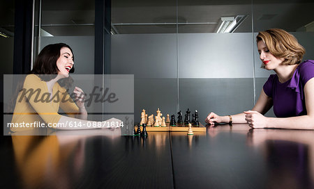 Two business executives playing chess in meeting room