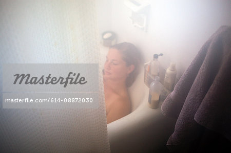 Woman relaxing in bathtub, high angle view