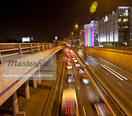 Traffic on road in urban scene at night, London, England