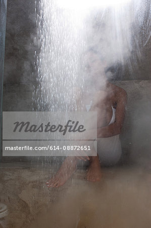 Woman sitting in rustic shower room