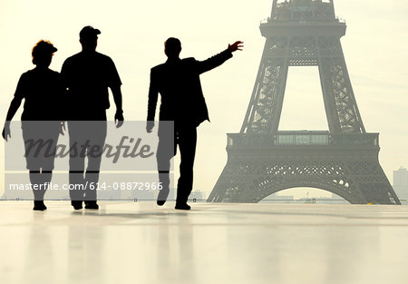 Silhouette of people walking in front of the Eiffel Tower
