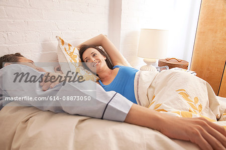 Mid adult couple relaxing in bed