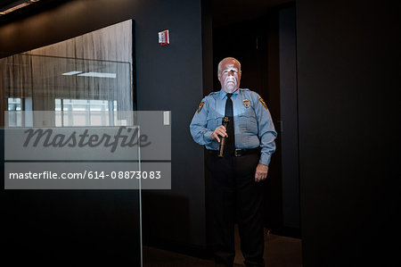 Security guard illuminating face with torch