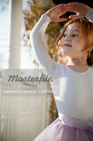 Girl dancing in ballet costume on porch