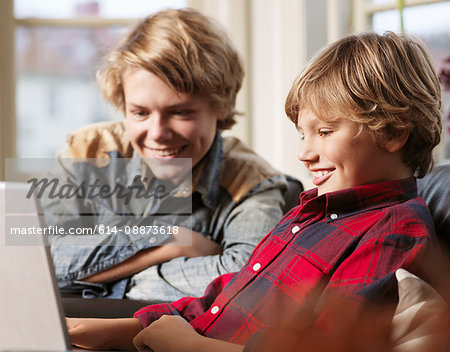 Teenage boy and brother watching laptop