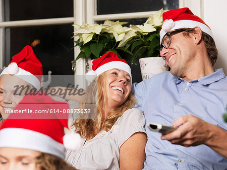 Family wearing Santa hats on sofa