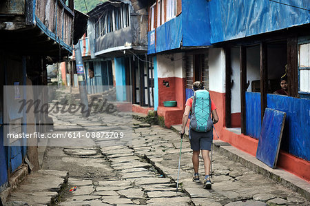 Woman treks through a small village, Bhulbhule, Nepal