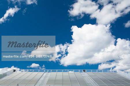 Blue sky and clouds above empty stadium seats