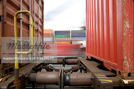 Train passing shipping containers