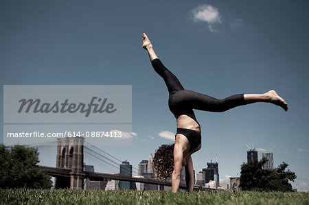 Woman doing handstand with legs apart