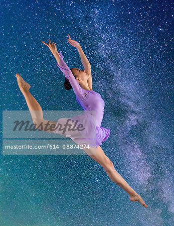 Ballerina leaping against starry night sky