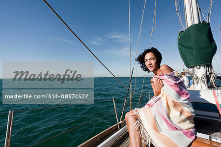 Young woman on yacht wrapped in blanket