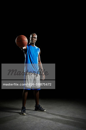 Studio portrait of basketball player holding ball Studio portrait of basketball player holding ball