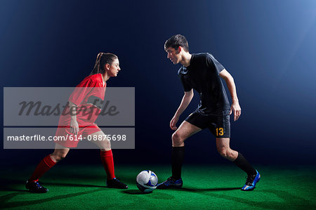 Male and female soccer players with ball