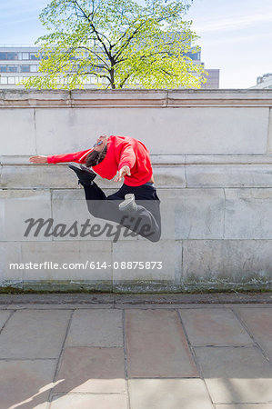Young male dancer mid air in city