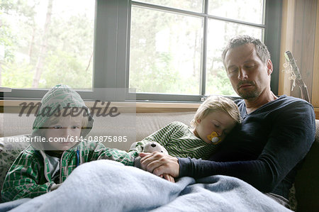 Father and sons resting on couch