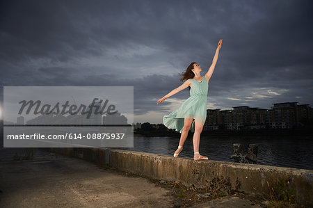 Ballet dancer reaching upwards on wall