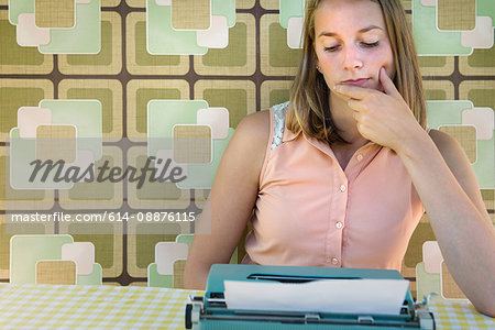 Adolescent girl sitting with typewriter