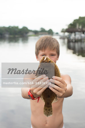 Portrait of boy holding up flounder, Shalimar, Florida, USA