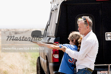 Father teaching son with rifle, Texas, USA