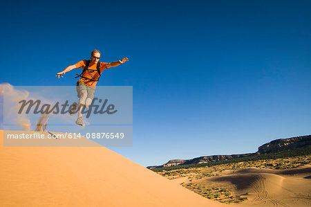 Male hiker running on Star Dune, Coral Pink Sand Dunes State Park, Utah, USA