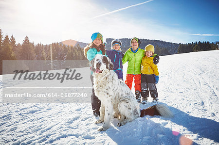 Children and pet dog enjoying playing in snow