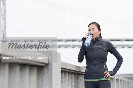Female runner drinking on bridge, San Francisco, California