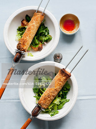 Spring rolls on skewers with salad bowls and dipping sauce