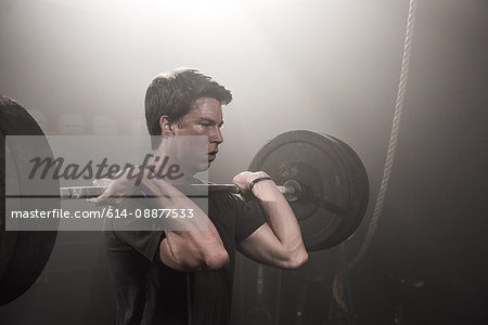 Young man lifting barbell