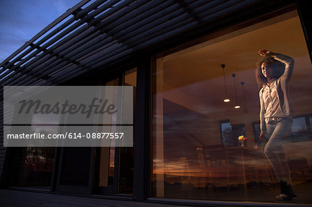 Woman looking through window at Cuillin mountain range, Isle of Skye, Scotland