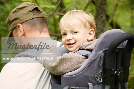 Portrait of male toddler in fathers hiking baby carrier, Bovec, Soca, Slovenia