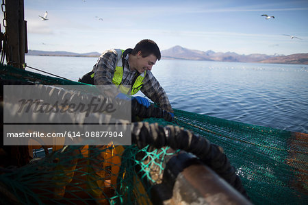 Fisherman releasing net into sea, Isle of Skye, Scotland
