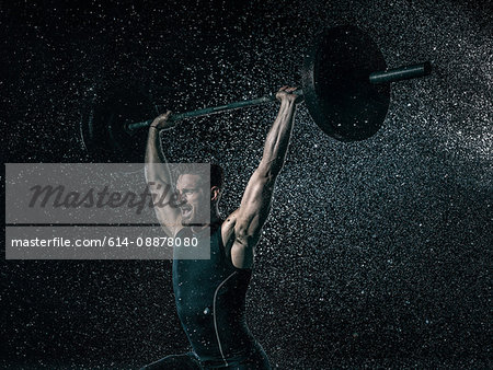 MId adult man, outdoors, lifting weights in rain