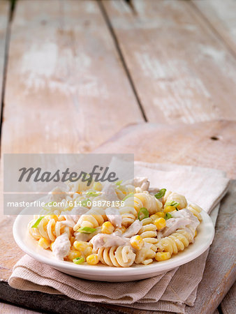 Still life of chicken and sweetcorn pasta with spring onion garnish in a bowl