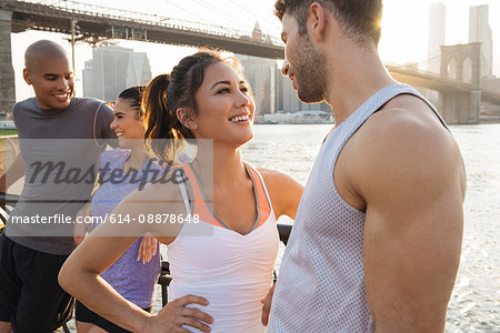 Young adult runners chatting on riverside, New York, USA