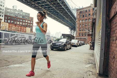 Young female runner running, New York, USA