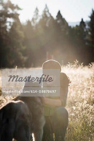 Mid adult woman crouching stroking dog smiling, Missoula, Montana, USA