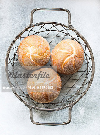 Overhead view of bread rolls in metal basket