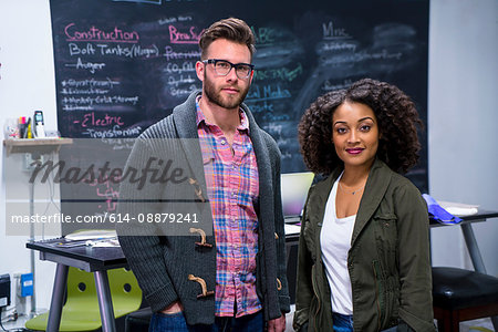 Colleagues in workplace looking at camera smiling