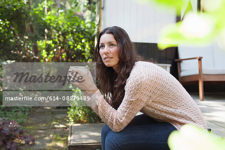 Young woman drinking coffee on chalet porch