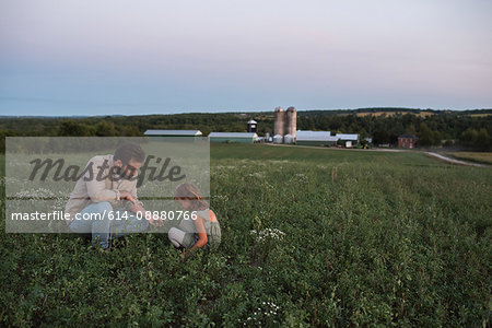 Father and daughter on farm, tending to crops