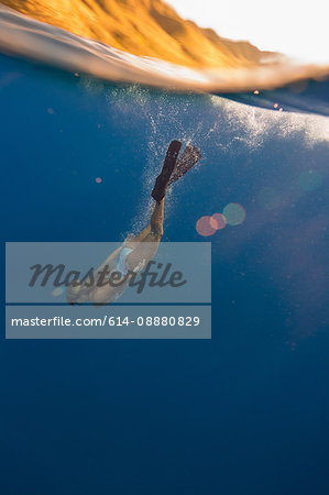 Woman wearing flippers swimming underwater, Oahu, Hawaii, USA