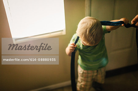 Young boy trying to put on neck tie