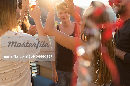 Adult friends partying and dancing on roof terrace