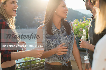 Four adult friends partying on waterfront roof terrace, Budapest, Hungary