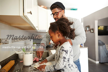 Father and daughter baking cookies together
